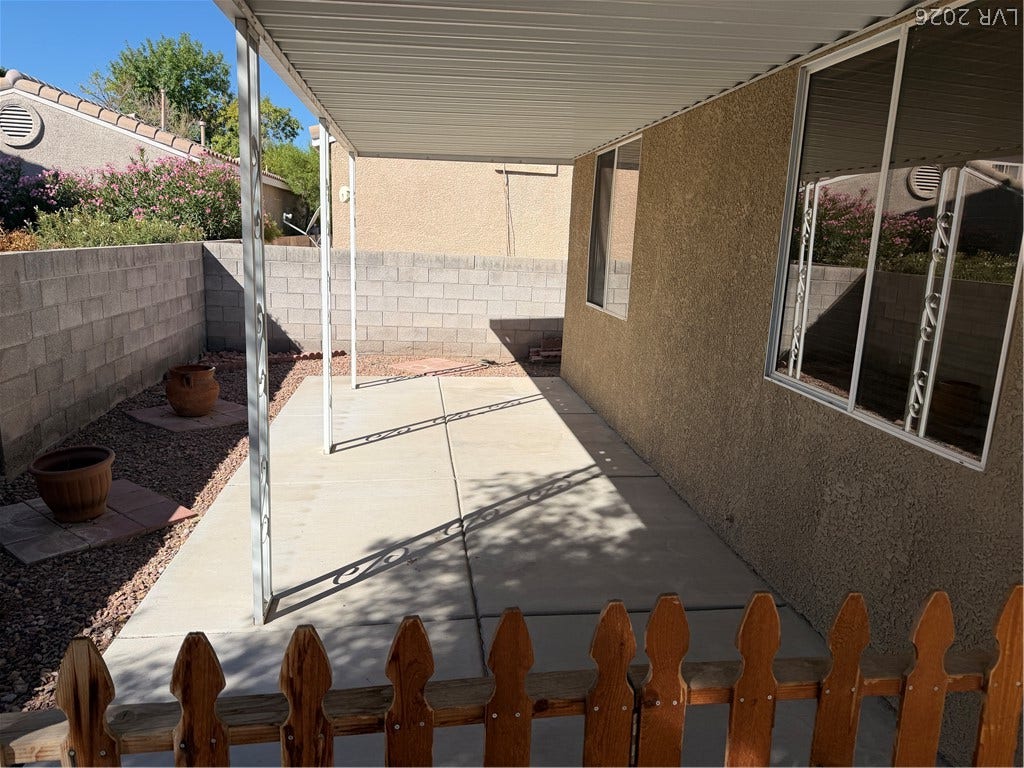 An inviting covered patio area transitions smoothly to the private yard.