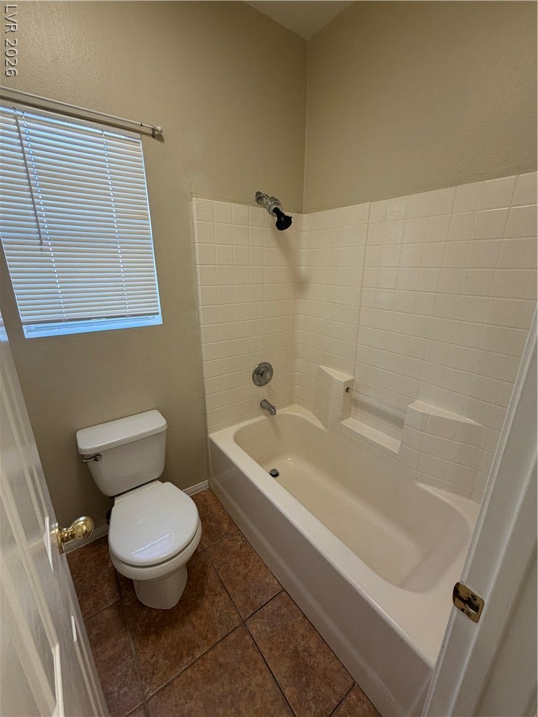 Tiled tub and shower surround complements the classic floor tiling in this functional bathroom.