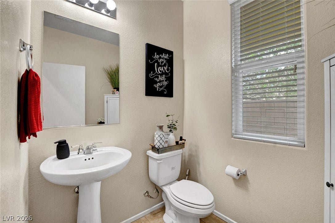 3924 Juanita May Avenue, North Las Vegas, NV 89032 A window brings natural light into this functional powder room with tile flooring.