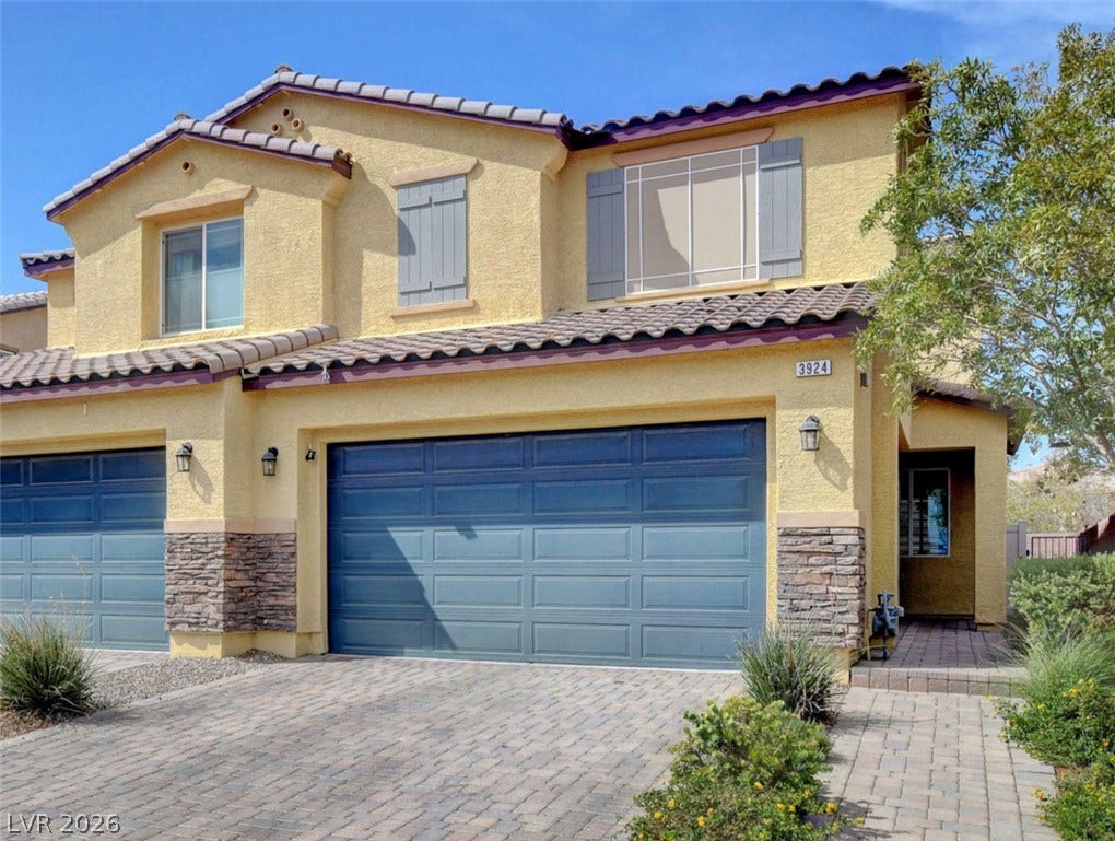 3924 Juanita May Avenue, North Las Vegas, NV 89032 Stone accents and decorative shutters enhance this two-story exterior featuring a paver driveway.