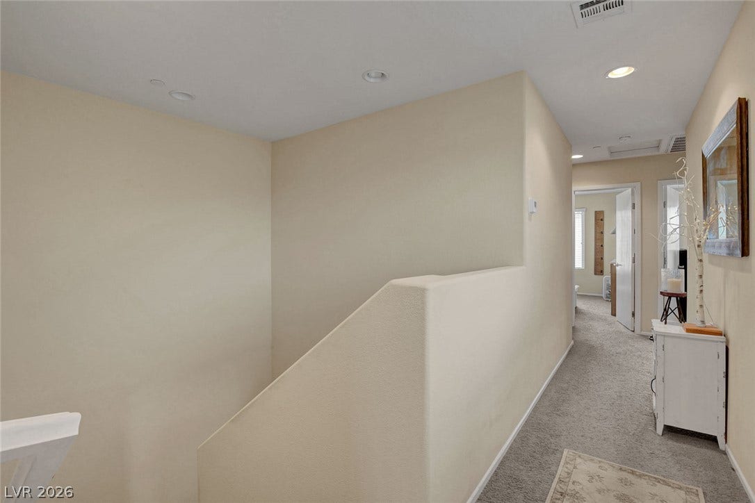 3924 Juanita May Avenue, North Las Vegas, NV 89032 Plush carpeting and soft neutral walls line this upper-level hallway leading from the staircase.