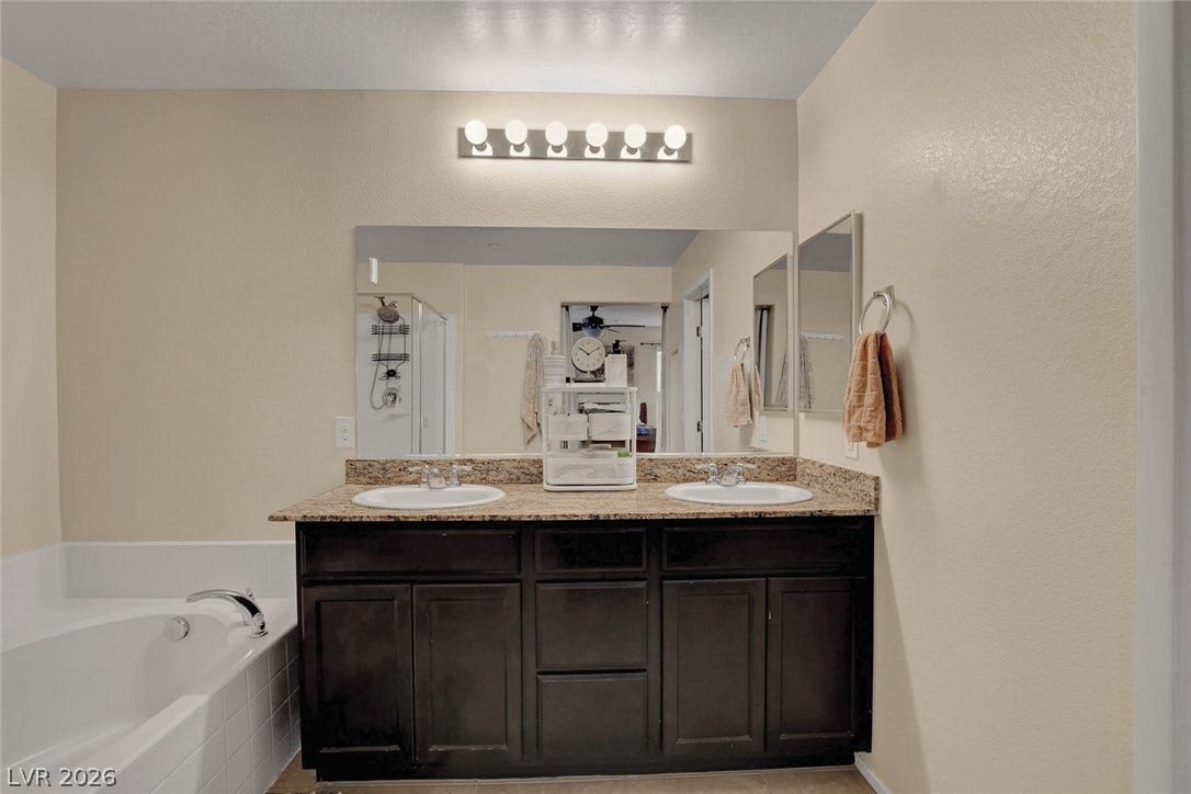 3924 Juanita May Avenue, North Las Vegas, NV 89032 Granite counters and a double vanity complement the soaking tub in this functional bathroom.