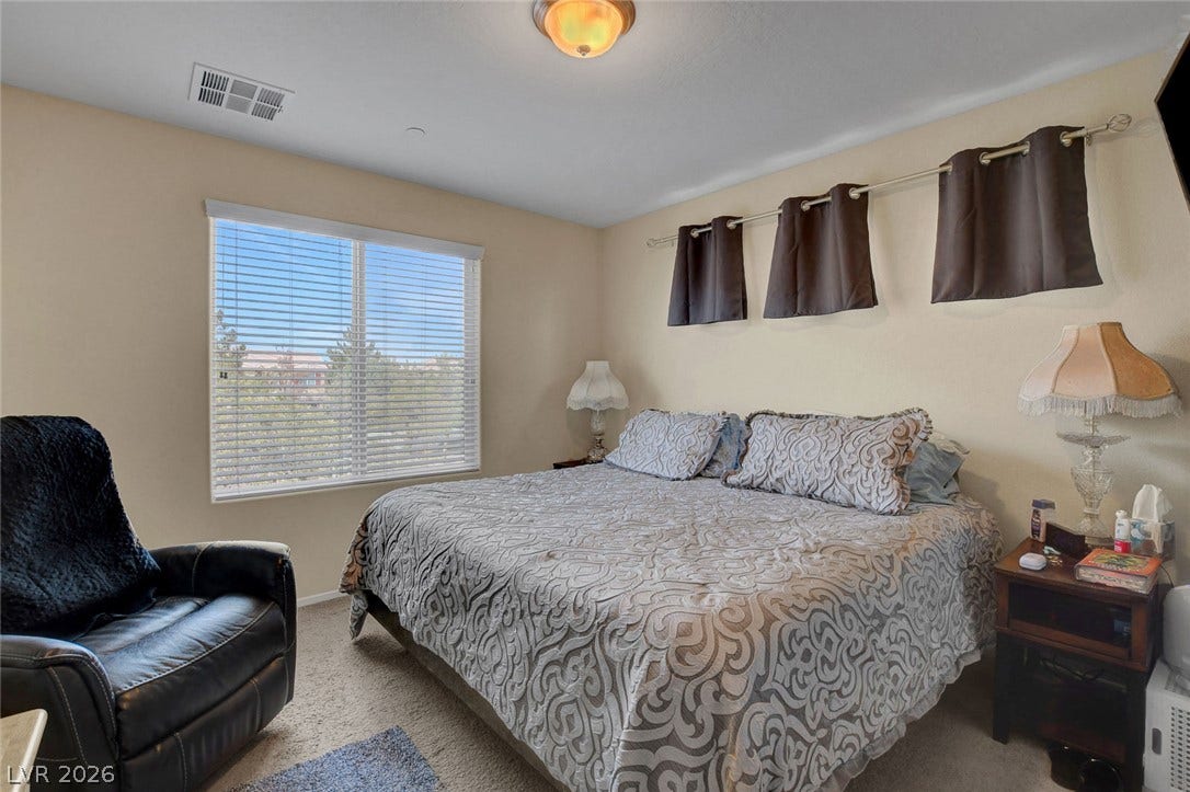 3924 Juanita May Avenue, North Las Vegas, NV 89032 A spacious bedroom features soft wall-to-wall carpeting and abundant natural light from a large window.