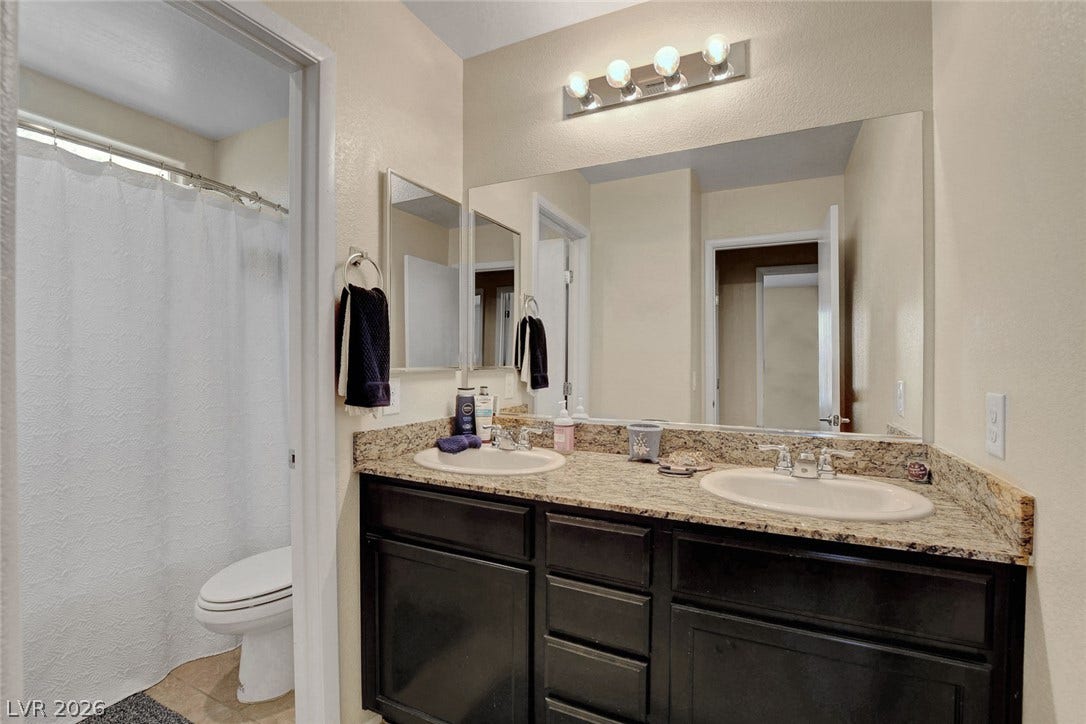 3924 Juanita May Avenue, North Las Vegas, NV 89032 A spacious double vanity with granite countertops anchors this functional bathroom layout.
