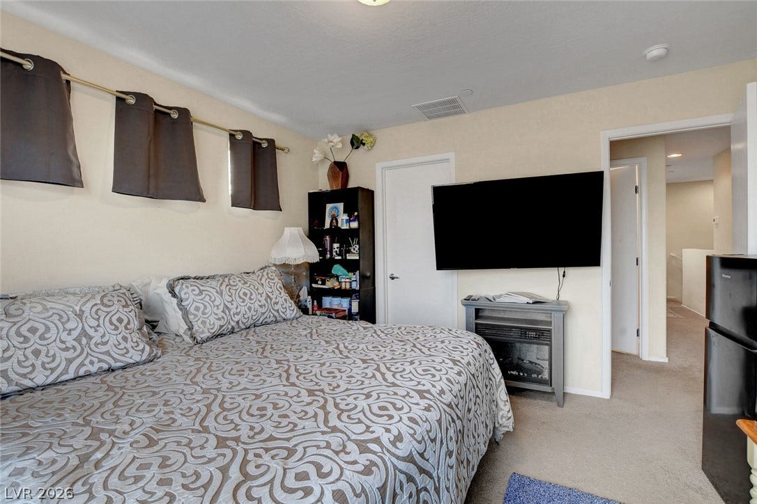3924 Juanita May Avenue, North Las Vegas, NV 89032 A spacious bedroom features soft carpet underfoot and connects directly to a hallway.