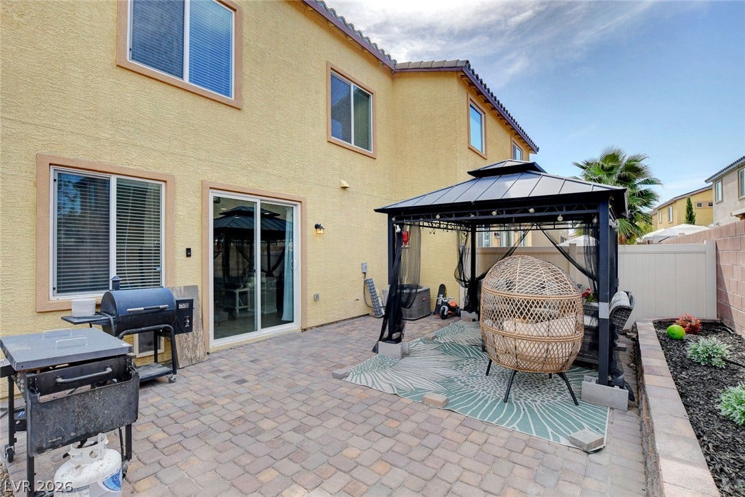 3924 Juanita May Avenue, North Las Vegas, NV 89032 A spacious paver patio sits outside sliding glass doors under a clear sky.