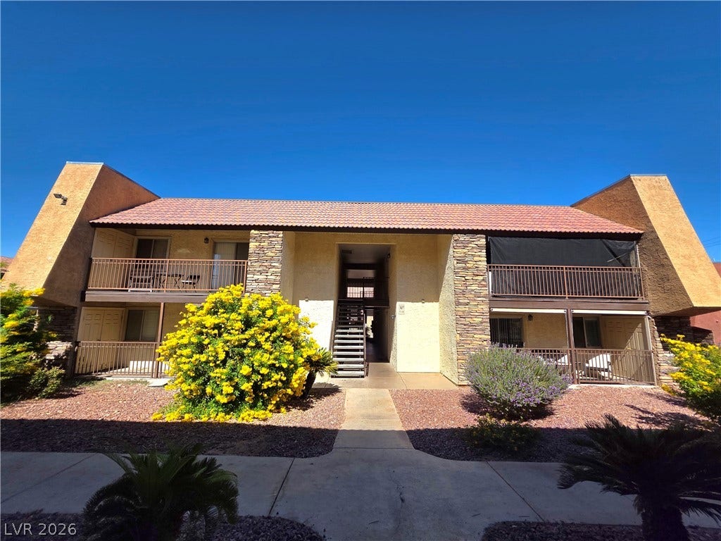 4470 Sandy River Drive, #54, Las Vegas, NV 89103 Distinctive stone-accented architecture defines this multi-level residential exterior under clear desert skies.