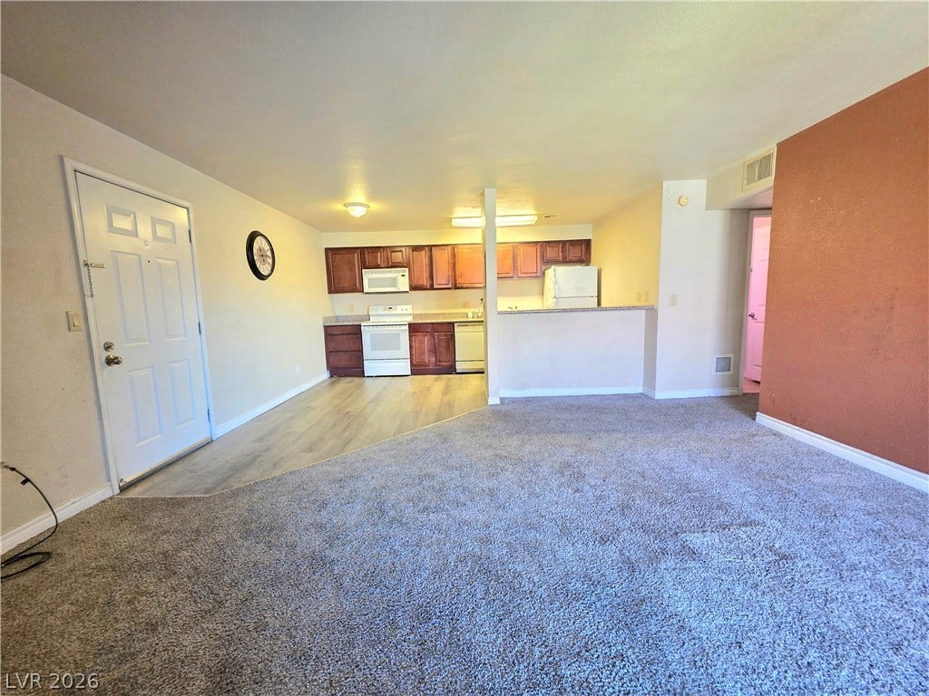 4470 Sandy River Drive, #54, Las Vegas, NV 89103 An open layout connects the carpeted living space directly to the kitchen area.