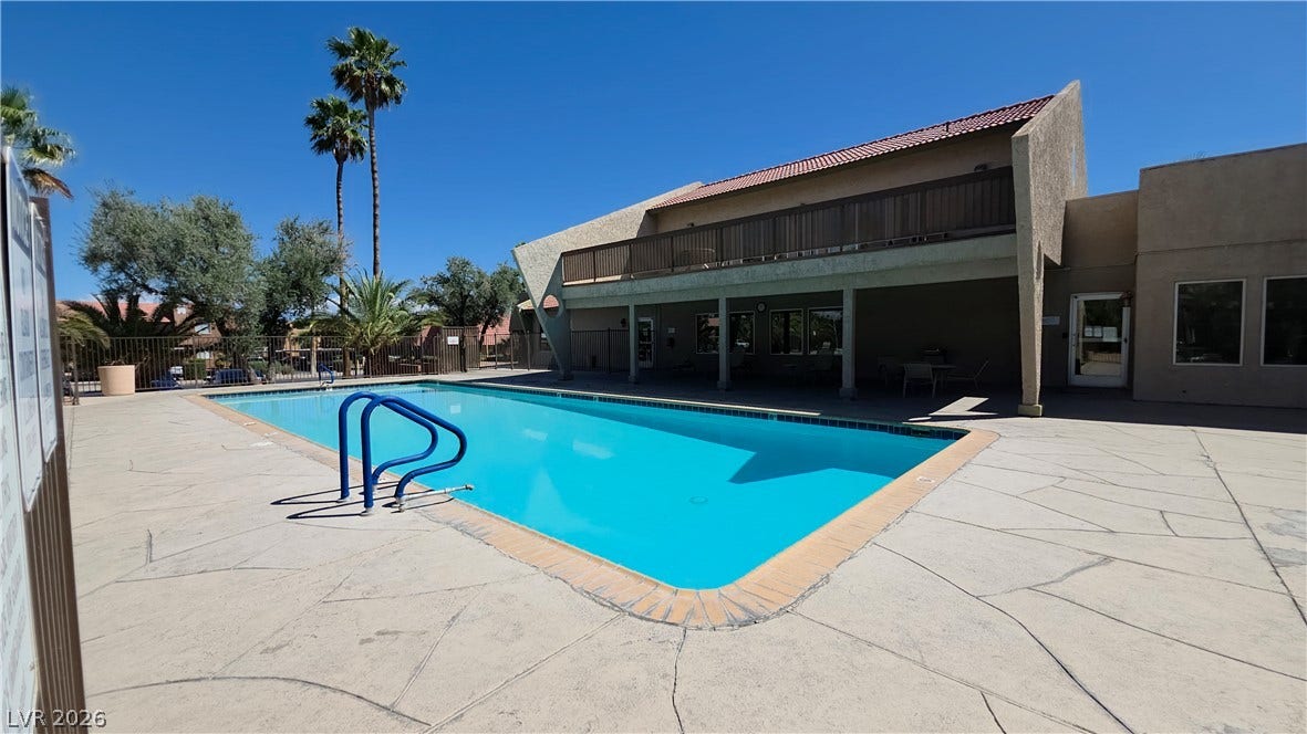 4470 Sandy River Drive, #54, Las Vegas, NV 89103 A spacious concrete deck surrounds the refreshing community swimming pool under clear blue skies.