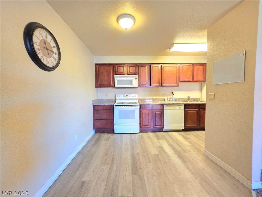 4470 Sandy River Drive, #54, Las Vegas, NV 89103 Rich wood cabinetry contrasts beautifully with the durable wood-look flooring in this functional kitchen.