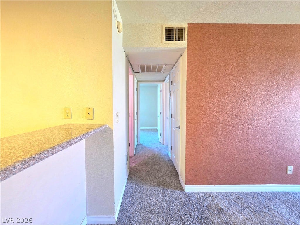 4470 Sandy River Drive, #54, Las Vegas, NV 89103 Plush carpeting runs through the hallway connecting the main living areas to the bedrooms.
