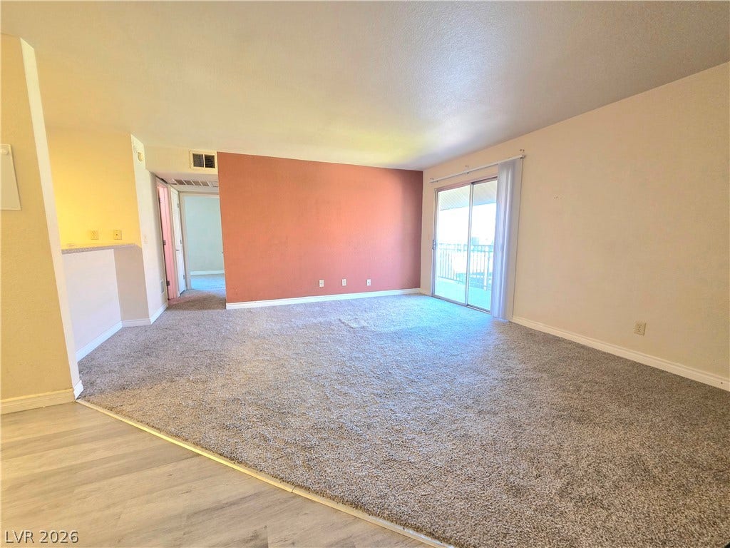 4470 Sandy River Drive, #54, Las Vegas, NV 89103 Sliding glass doors open to a private balcony from this spacious carpeted living area.