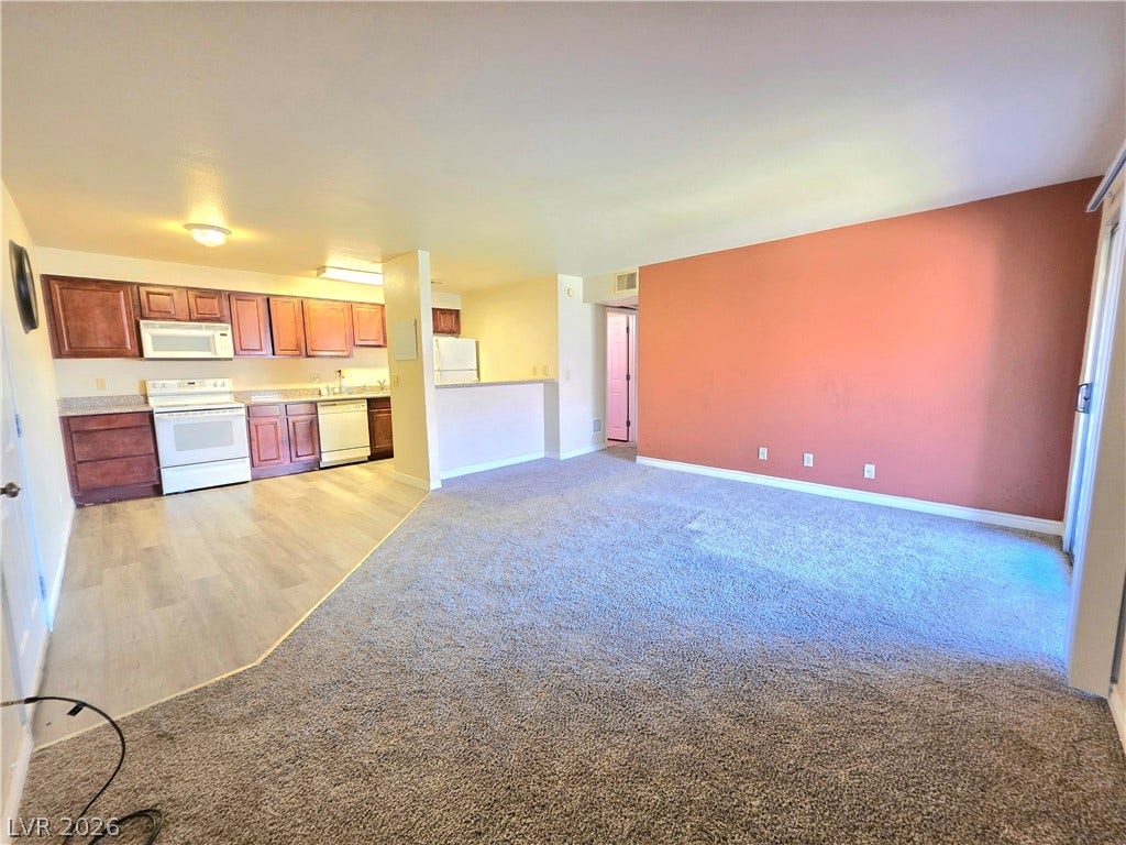 4470 Sandy River Drive, #54, Las Vegas, NV 89103 An open floor plan seamlessly connects the carpeted living area to the adjacent kitchen.