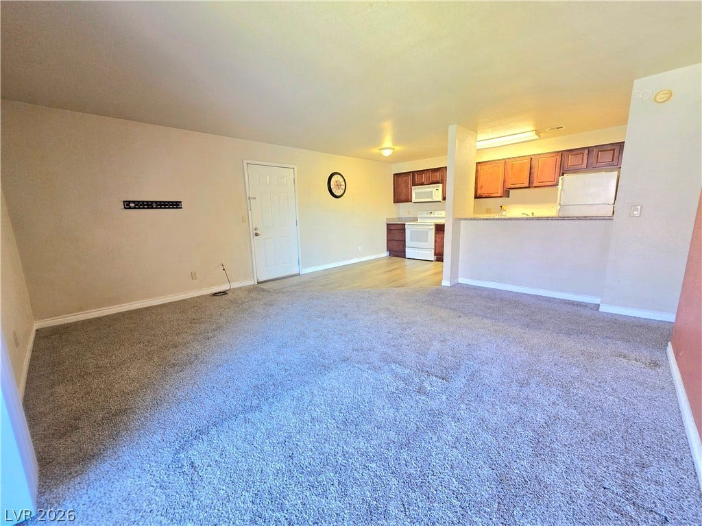 4470 Sandy River Drive, #54, Las Vegas, NV 89103 An open layout connects the carpeted living space directly to the kitchen area.