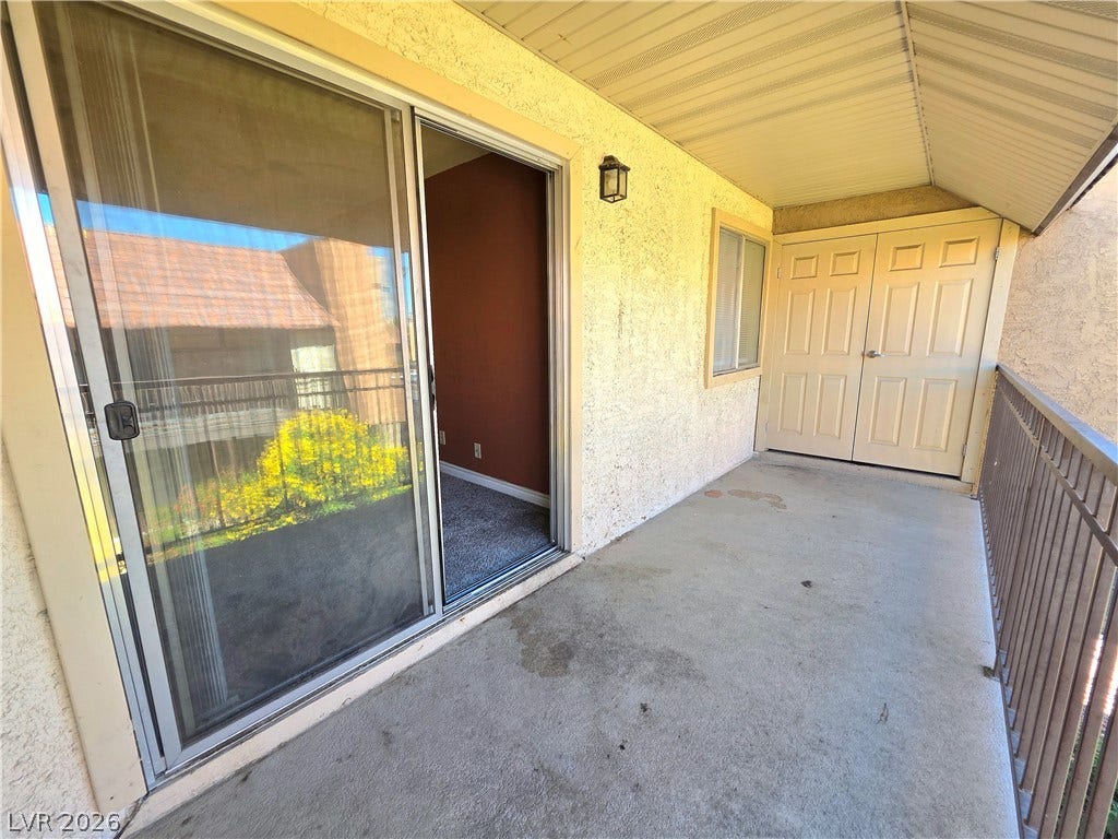 4470 Sandy River Drive, #54, Las Vegas, NV 89103 Covered concrete balcony features sturdy metal railings and sliding glass door access.