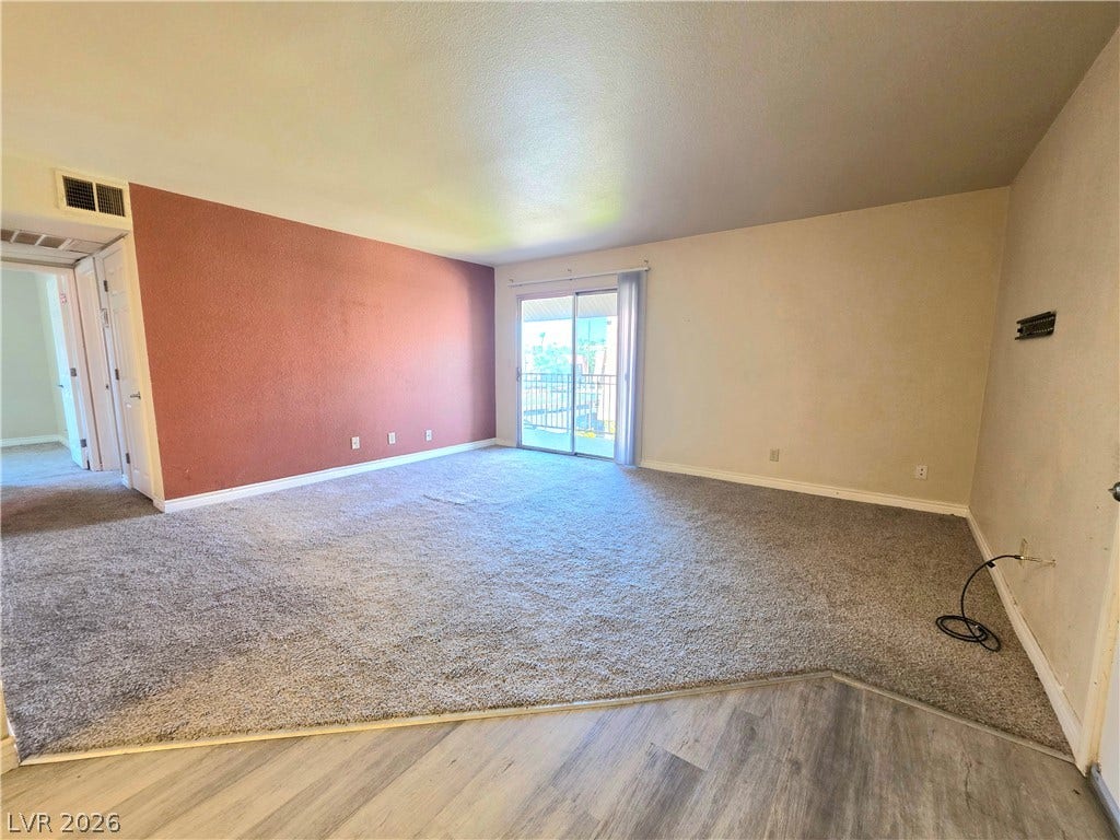 4470 Sandy River Drive, #54, Las Vegas, NV 89103 Sliding glass doors open to a private balcony from this spacious living area.