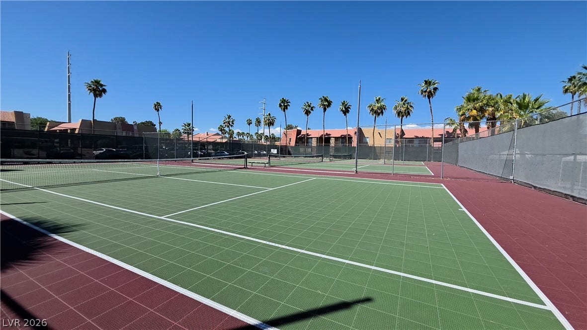 4470 Sandy River Drive, #54, Las Vegas, NV 89103 Fenced sports courts sit surrounded by mature palm trees under clear blue skies.