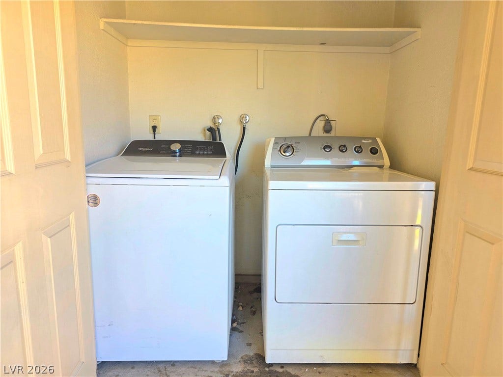 4470 Sandy River Drive, #54, Las Vegas, NV 89103 A functional laundry alcove features built-in shelving overhead and concrete flooring.