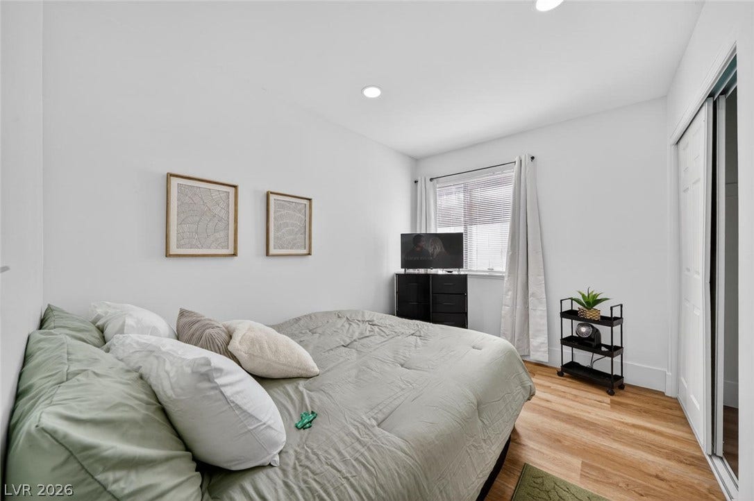 6191 Bullion Boulevard, Las Vegas, NV 89103 Recessed lighting and warm wood-style flooring elevate this comfortable bedroom space.