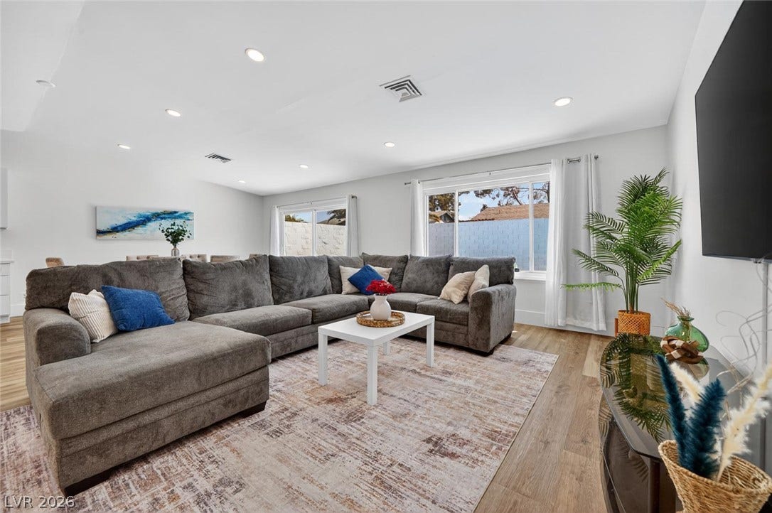6191 Bullion Boulevard, Las Vegas, NV 89103 Recessed lighting and warm wood flooring enhance this modern, open-concept living area.