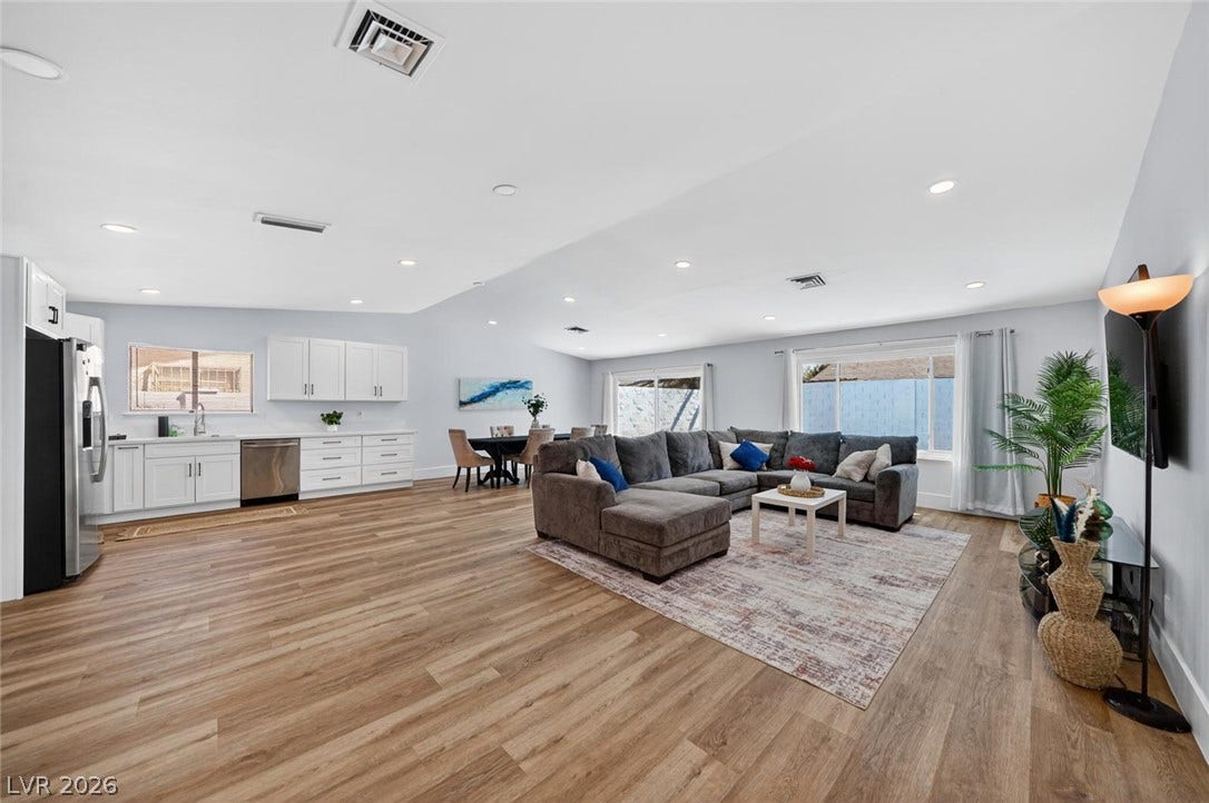 6191 Bullion Boulevard, Las Vegas, NV 89103 Gleaming wood-look floors anchor a sweeping, open-concept living area illuminated by recessed lighting.