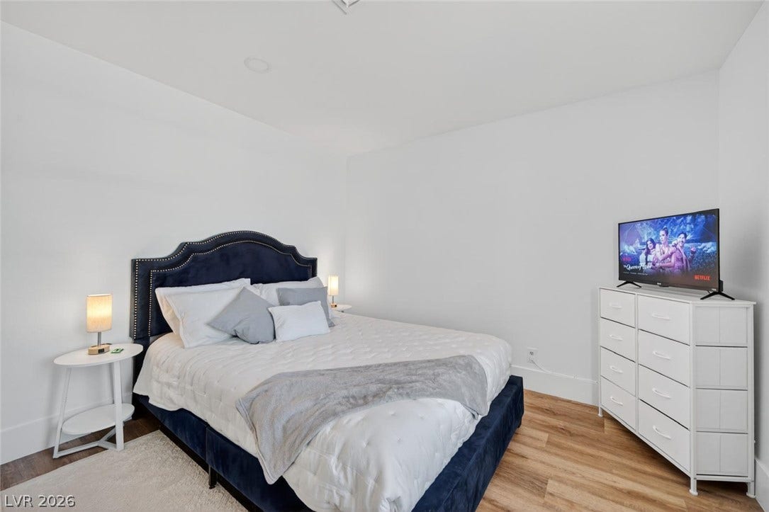 6191 Bullion Boulevard, Las Vegas, NV 89103 Crisp white walls complement the warm wood flooring in this inviting bedroom space.