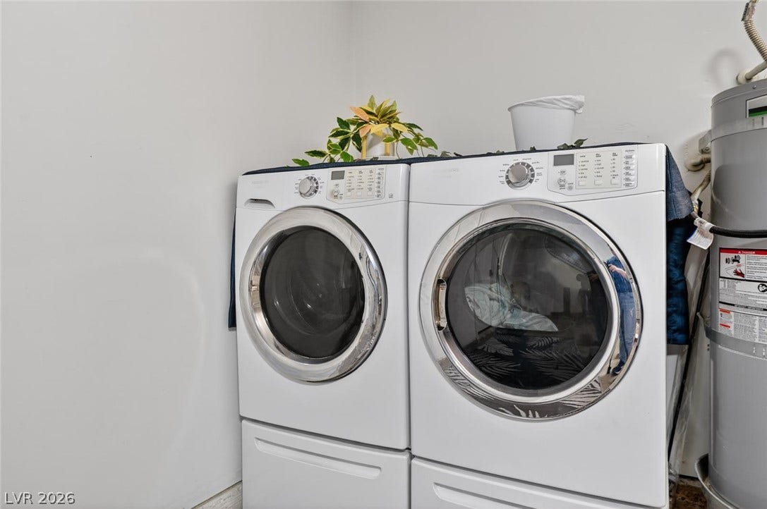 6191 Bullion Boulevard, Las Vegas, NV 89103 A dedicated laundry area features front-loading appliances set on pedestals next to the water heater.