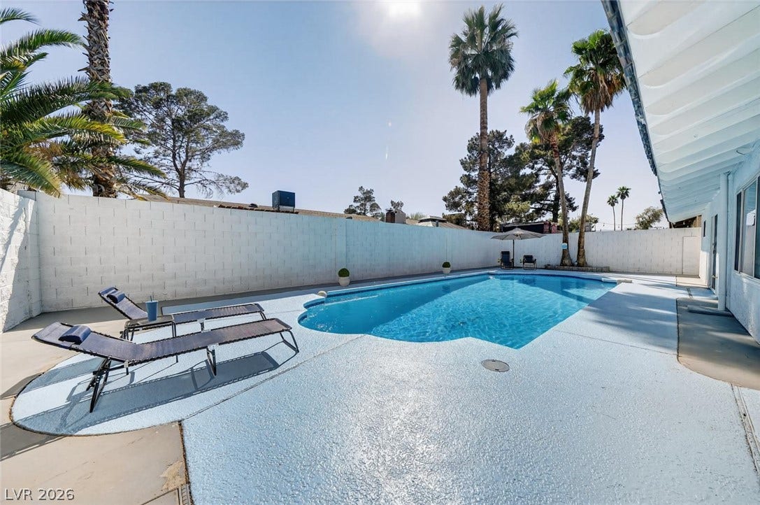 6191 Bullion Boulevard, Las Vegas, NV 89103 An inviting swimming pool is enclosed by a privacy wall and flanked by towering palms.