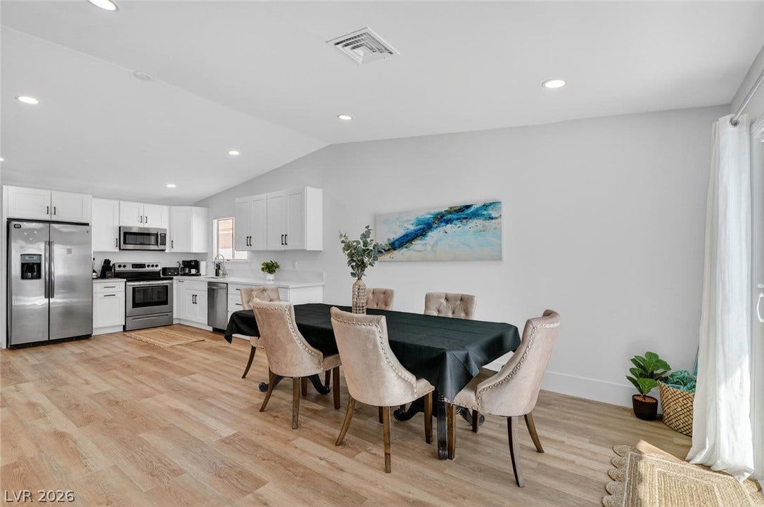 6191 Bullion Boulevard, Las Vegas, NV 89103 Seamless transition from the dining space to a modern kitchen over handsome wood flooring.