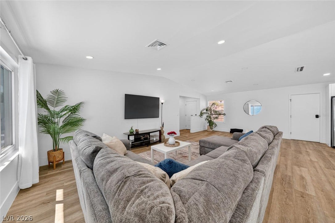 6191 Bullion Boulevard, Las Vegas, NV 89103 Smooth plaster walls and rich wood-texture flooring highlight this open, airy living space.