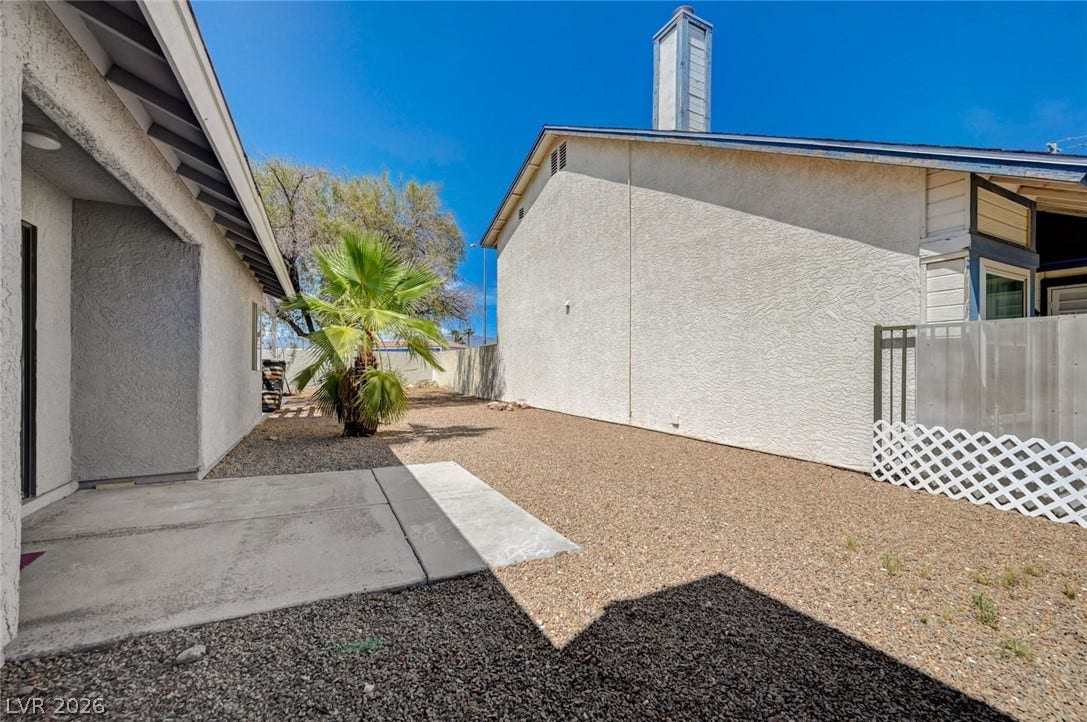 6712 Accent Court, Las Vegas, NV 89108 Low-maintenance gravel landscaping fills the sunny back yard flanked by stucco home exteriors.