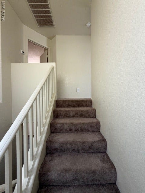 2506 Lady Elizabeth Court, North Las Vegas, NV 89031 Plush carpeted stairs ascend past a classic white banister in this inviting entryway.