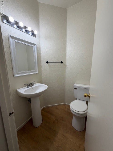2506 Lady Elizabeth Court, North Las Vegas, NV 89031 Warm wood flooring pairs beautifully with a classic pedestal sink in this clean powder room.