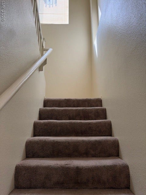 2506 Lady Elizabeth Court, North Las Vegas, NV 89031 Natural light streams through overhead skylights to illuminate the carpeted staircase and neutral walls.