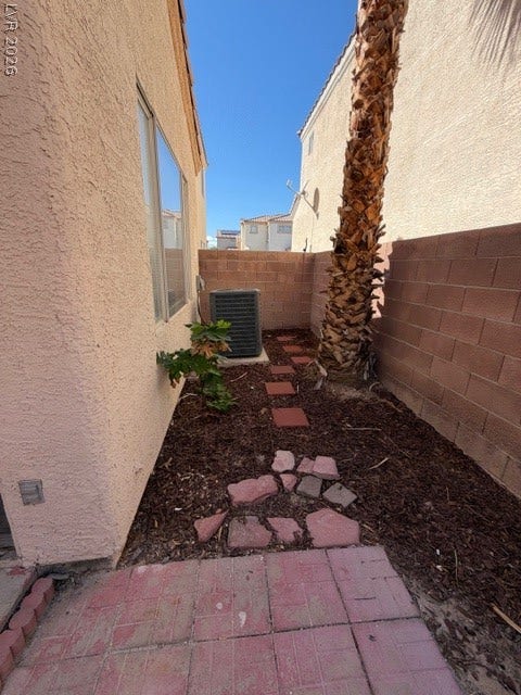 2506 Lady Elizabeth Court, North Las Vegas, NV 89031 A narrow side yard walkway is enclosed by a stucco home exterior and block walls.