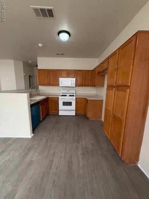 2506 Lady Elizabeth Court, North Las Vegas, NV 89031 Ample wooden cabinetry and durable vinyl plank flooring define this functional kitchen layout.