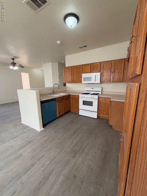 2506 Lady Elizabeth Court, North Las Vegas, NV 89031 Ample wooden cabinetry and durable vinyl plank flooring define this functional kitchen space.