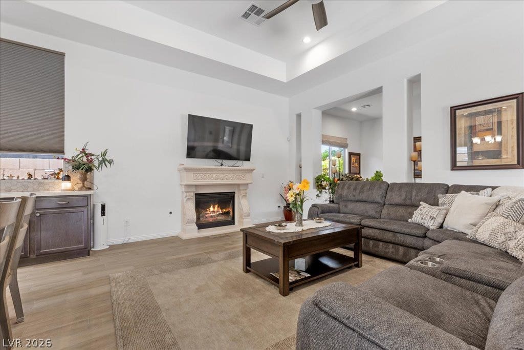 6722 Desert Crimson Street, Las Vegas, NV 89148 A refined fireplace and elegant tray ceiling anchor this open-concept main living space.