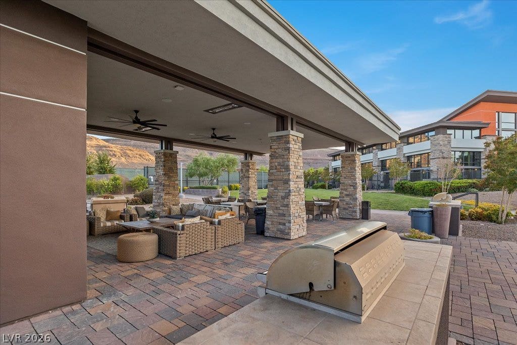 6722 Desert Crimson Street, Las Vegas, NV 89148 An expansive covered patio features stone pillars, paved flooring, and a built-in outdoor kitchen.