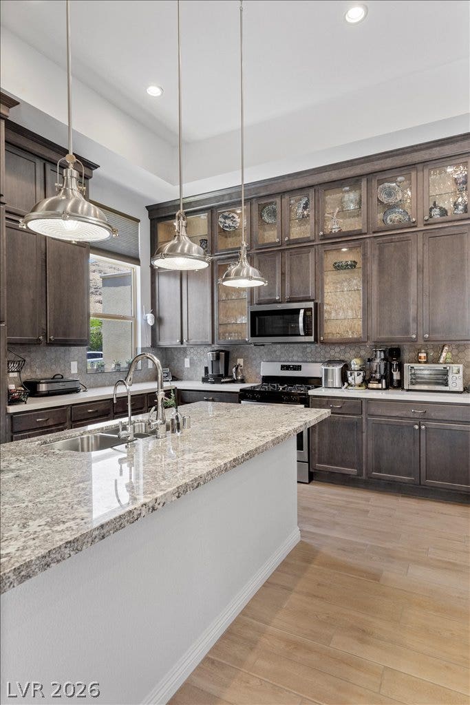 6722 Desert Crimson Street, Las Vegas, NV 89148 Polished granite countertops complement custom dark cabinetry in this open kitchen layout.