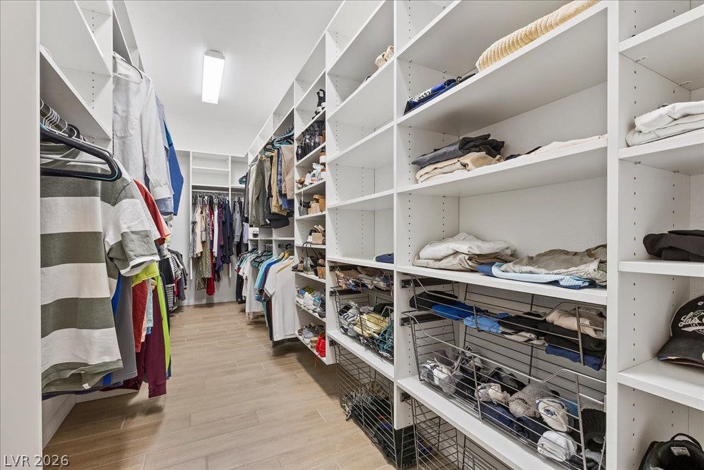 6722 Desert Crimson Street, Las Vegas, NV 89148 A spacious walk-in closet boasts extensive custom built-in shelving and light wood-look flooring.
