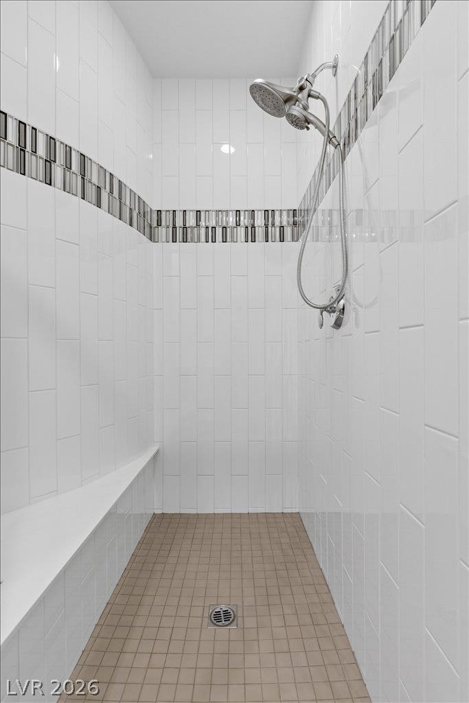 6722 Desert Crimson Street, Las Vegas, NV 89148 Floor-to-ceiling tiling and a built-in bench highlight this modern walk-in shower.