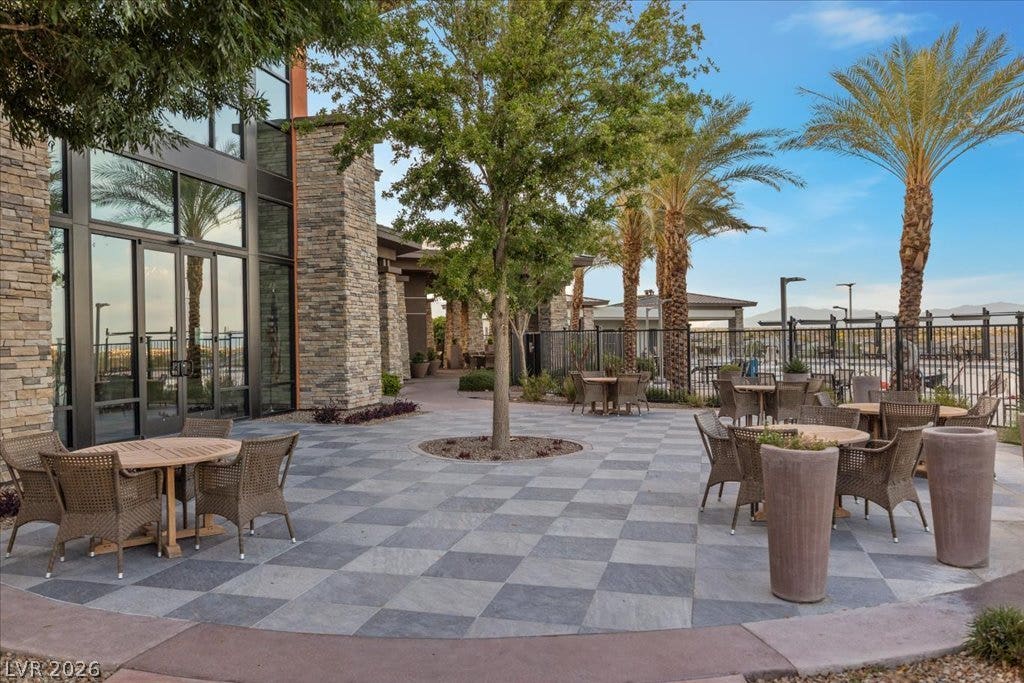 6722 Desert Crimson Street, Las Vegas, NV 89148 An inviting stone-paved plaza surrounded by architectural stone pillars and lush palm trees.