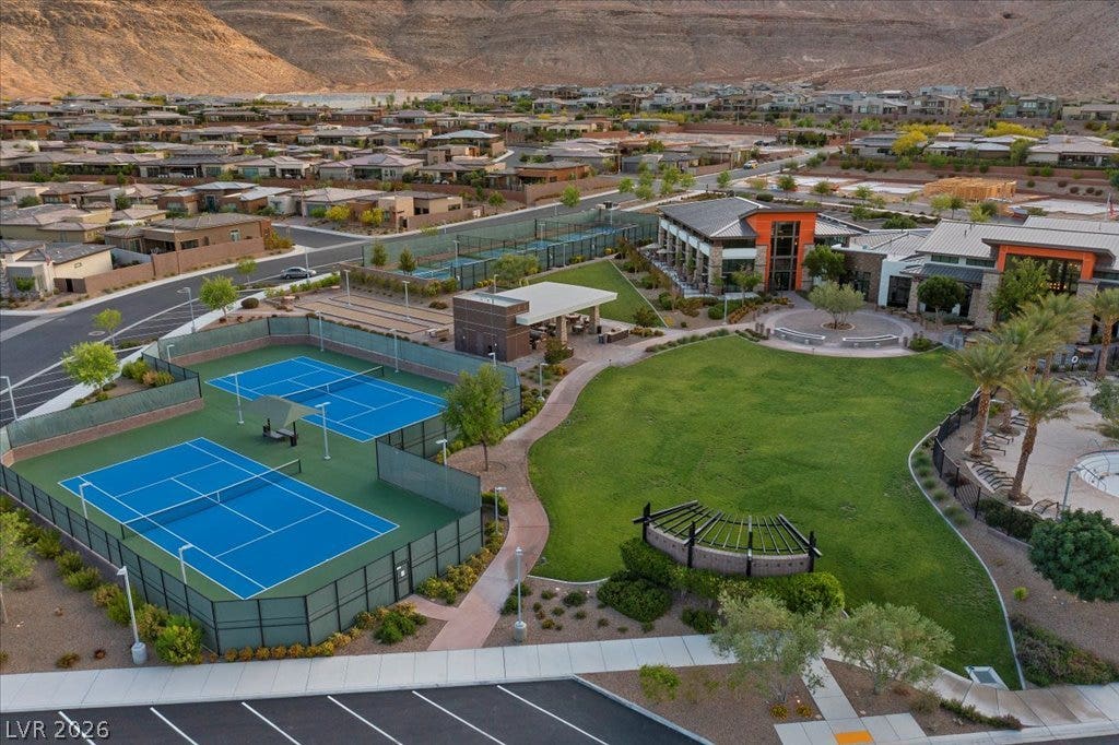 6722 Desert Crimson Street, Las Vegas, NV 89148 A sweeping aerial view showcases pristine community recreation courts set against a rugged mountain backdrop.