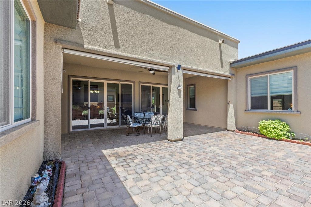 6722 Desert Crimson Street, Las Vegas, NV 89148 An inviting stone-paved patio offers shaded outdoor space next to glass sliding doors.