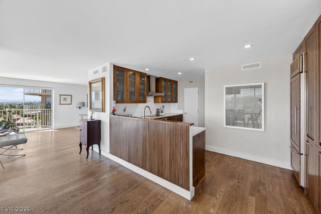 3111 Bel Air Drive, #7D, Las Vegas, NV 89109 Gleaming hardwood floors and recessed lighting flow through this open-concept kitchen and living area.