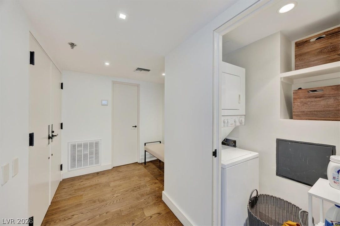 3111 Bel Air Drive, #7D, Las Vegas, NV 89109 Rich hardwood flooring anchors this clean interior hallway leading to a dedicated laundry closet.