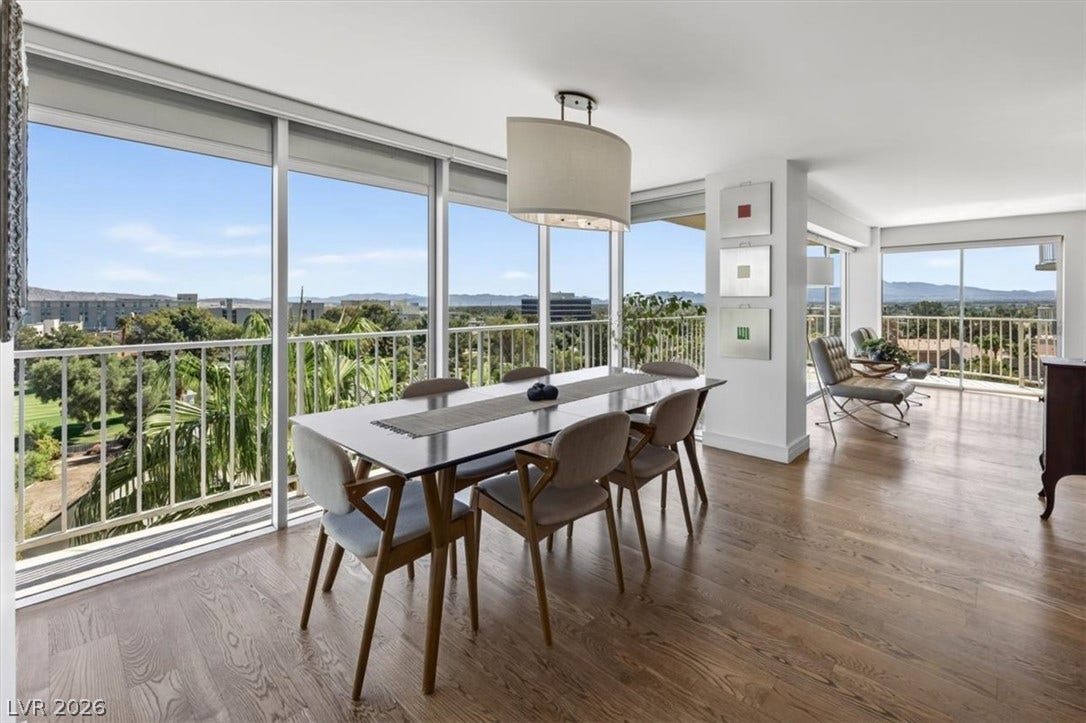 3111 Bel Air Drive, #7D, Las Vegas, NV 89109 Floor-to-ceiling glass walls frame sprawling neighborhood and mountain views across the open dining area.