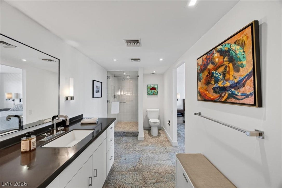 3111 Bel Air Drive, #7D, Las Vegas, NV 89109 Gleaming stone countertops and textured tile flooring elevate this contemporary bathroom space.