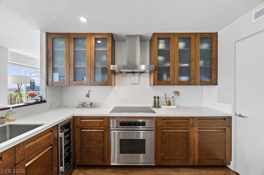 3111 Bel Air Drive, #7D, Las Vegas, NV 89109 Rich wood cabinetry contrasts beautifully with clean white countertops and modern stainless steel appliances.